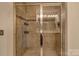 Modern shower enclosed in glass, accented with neutral tile and built-in shelving for toiletries at 3159 Hartson Pointe Dr, Fort Mill, SC 29707