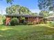 Back exterior featuring a brick home, wooden deck, and well-maintained yard at 331 Elwood St, Kannapolis, NC 28081