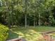 Backyard featuring mature trees and landscaping with a bench at 331 Elwood St, Kannapolis, NC 28081