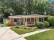 Close-up of a brick home featuring a welcoming front porch and well-maintained landscaping at 331 Elwood St, Kannapolis, NC 28081
