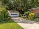 View of the detached garage and driveway surrounded by lush landscaping at 331 Elwood St, Kannapolis, NC 28081