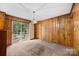 Spacious living room with wood paneling, carpet, and sliding glass doors to the outdoor deck at 331 Elwood St, Kannapolis, NC 28081