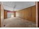 Bright living room with wood paneling, carpet flooring, and sliding glass door to the backyard at 331 Elwood St, Kannapolis, NC 28081