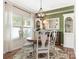 Bright dining room featuring a round wood table, chandelier, and built-in shelving and a large window at 342 Battery Cir, Clover, SC 29710