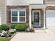 Close up of home's entrance with lovely rock facade, decorative door, manicured shrubs, and beautiful flowers at 342 Battery Cir, Clover, SC 29710