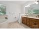 Bright bathroom featuring tile floors, dual sinks and a soaking tub at 3701 Bounty Ct, Matthews, NC 28104