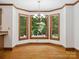 Bright dining area featuring hardwood floors, trim and large windows overlooking a lush backyard at 3701 Bounty Ct, Matthews, NC 28104
