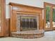Close-up of a classic brick fireplace with wood mantle and hearth, flanked by doors at 3701 Bounty Ct, Matthews, NC 28104
