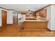 Open-concept kitchen with wood cabinets, stainless steel appliances, and breakfast bar, leading into other living spaces at 3701 Bounty Ct, Matthews, NC 28104