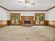 Bright living room featuring a brick fireplace, wood trim, and access to outdoor spaces at 3701 Bounty Ct, Matthews, NC 28104
