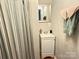 Bathroom with a single vanity, shower curtain, and a mirror with brushed silver frame at 409 W Norment Ave, Gastonia, NC 28052