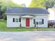 Charming bungalow with a bright red door, complemented by black shutters and manicured landscaping at 409 W Norment Ave, Gastonia, NC 28052
