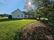 Large backyard with a well-maintained lawn, mature trees, and a wooden deck perfect for outdoor enjoyment at 417 Garret Ln, York, SC 29745
