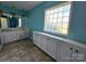 The bright bathroom offers a dual vanity, glass block window, ample cabinet space, and tiled floors at 417 Garret Ln, York, SC 29745