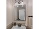 A stylish bathroom featuring wallpaper, a modern light fixture, a framed mirror, and a white sink basin at 4209 Windwood Cir, Charlotte, NC 28226