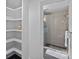 Bright bathroom featuring a glass enclosed shower, built-in storage shelves, and dark floors at 4209 Windwood Cir, Charlotte, NC 28226