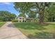 Beautifully landscaped home featuring a lush green lawn, large shade tree and a long drive way at 4209 Windwood Cir, Charlotte, NC 28226