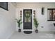 An elegant front door with glass and wreath, flanked by plants and sidelights, with modern exterior lighting at 4209 Windwood Cir, Charlotte, NC 28226