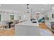 Spacious kitchen with center island and modern pendants, open concept floor plan, and an adjacent dining area at 4209 Windwood Cir, Charlotte, NC 28226