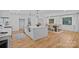 Beautiful open concept kitchen with white cabinets, quartz countertops, hardwood floors, and modern lighting at 4209 Windwood Cir, Charlotte, NC 28226