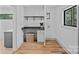 Functional laundry room with counter space, overhead shelving, and natural light at 4209 Windwood Cir, Charlotte, NC 28226