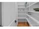 Walk-in pantry offers ample storage with custom built-in shelving and hardwood floors at 4209 Windwood Cir, Charlotte, NC 28226