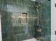 Modern shower with stylish green tile, built-in niche, and bronze fixtures at 4209 Windwood Cir, Charlotte, NC 28226
