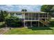 Spacious backyard featuring a lush lawn, mature trees, landscape rocks and a screened-in porch attached to the home at 4278 Harbor Ln, Sherrills Ford, NC 28673