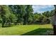 Expansive backyard with lush green lawn, mature trees, and a wooden fence creating a private outdoor space at 4278 Harbor Ln, Sherrills Ford, NC 28673