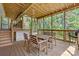 View of the wooden screened-in porch with table and chairs, overlooking a wooded area at 4278 Harbor Ln, Sherrills Ford, NC 28673