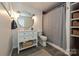 Charming bathroom features a modern vanity, circular mirror and exposed brick detail in the shower at 5301 Addison Dr, Charlotte, NC 28211