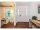 Inviting foyer with a white front door, hardwood floors, and view into the living room at 5301 Addison Dr, Charlotte, NC 28211