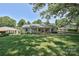Inviting single-story home featuring a green lawn and mature trees in a serene neighborhood setting at 5301 Addison Dr, Charlotte, NC 28211