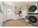 Mudroom features a modern washer and dryer, white cabinets, and tiled floors at 5301 Addison Dr, Charlotte, NC 28211