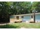Home's backyard featuring a small deck, a door, and a windmill, all surrounded by mature trees at 561 Woodglenn Rd, Catawba, SC 29704