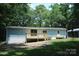 Exterior view of a light blue house with a small back deck and backyard in a lush green surrounding at 561 Woodglenn Rd, Catawba, SC 29704