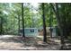Exterior shot of a light blue house with a covered car port surrounded by lots of trees at 561 Woodglenn Rd, Catawba, SC 29704