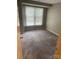 Comfortable bedroom with neutral walls, plush carpeting, and a large, bright window at 6260 Rosecroft Dr, Charlotte, NC 28215