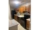 Well-equipped kitchen features black appliances, wood cabinets, and sleek granite countertops at 6260 Rosecroft Dr, Charlotte, NC 28215