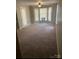 An airy living room showcases plush carpeting, bay windows, and ample natural light at 6260 Rosecroft Dr, Charlotte, NC 28215