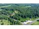 Scenic aerial view of a wooded property featuring a home nestled among mature trees and open spaces at 6314 Providence Church Rd, Vale, NC 28168
