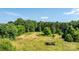 Large open field surrounded by lush greenery, presenting possibilities for outdoor recreation or gardening at 6314 Providence Church Rd, Vale, NC 28168