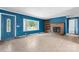 Open living room with a decorative fireplace, large window, and blue painted walls at 6314 Providence Church Rd, Vale, NC 28168