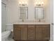 Bathroom featuring a double vanity with dark wood cabinets, granite counters, and ample lighting at 633 Portside Dr, Davidson, NC 28036