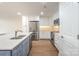 Modern kitchen with stainless steel appliances, white cabinets, gray island, and hardwood floors at 633 Portside Dr, Davidson, NC 28036