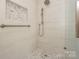 This renovated bathroom features a glass shower with decorative tile inset and brushed nickel fixtures at 633 Portside Dr, Davidson, NC 28036