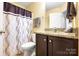 Bathroom with a shower/tub combo, granite countertop and dark wood cabinets at 7327 Snowbird Ct, Mint Hill, NC 28227