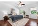 Bright bedroom featuring hardwood floors, a ceiling fan, and windows offering natural light at 7327 Snowbird Ct, Mint Hill, NC 28227