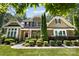 Charming brick home featuring manicured landscaping, an American flag, and a welcoming entrance at 7327 Snowbird Ct, Mint Hill, NC 28227