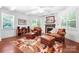 Bright living room features two seating areas with leather chairs, ottomans, and a cozy fireplace at 7327 Snowbird Ct, Mint Hill, NC 28227